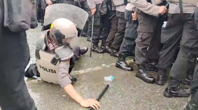 Seorang polisi terjatuh saat melakukan mengamankan aksi unjuk rasa pada simulasi sistem pengamanan kota dalam rangka pilkada serentak oleh Polresta Palu di Palu, Kamis (22/8/2024). (Foto: Humas Polresta Palu)