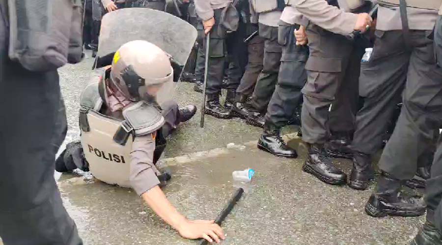Seorang polisi terjatuh saat melakukan mengamankan aksi unjuk rasa pada simulasi sistem pengamanan kota dalam rangka pilkada serentak oleh Polresta Palu di Palu, Kamis (22/8/2024). (Foto: Humas Polresta Palu)