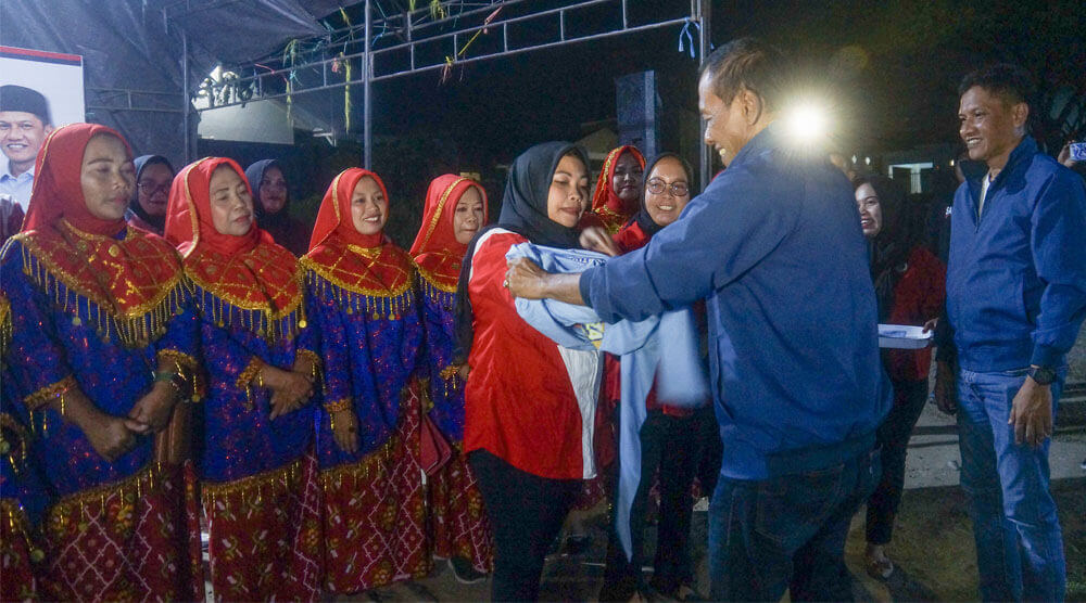 Hidayat bersama Andi Nur B Lamakarate memasangkan rompi kepada Relawan Srikandi HANDAL usai pengukuhan di Lapangan Sepakbola Mantikulore, Tanamodindi, Sabtu (14/9/2024) malam. (Foto: Tim Media HANDAL)