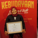 Iin Ainar Lawide memegang piagam penghargaan yang baru saja diterimanya dalam Anugerah Kebudayaan 2024 Kemendikbud Ristek di Jakarta, Selasa (17/9/2024). (Foto: ist)