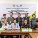 Dari kiri depan ke kanan: Sekrterais KPU Kota Palu Aslim Adigama, Kepala Kesbangpol Kota Palu Ansyar Sutadi, Kepala BPJS Ketenagakerjaan Cabang Palu Syamsul Rijal, Ketua KPU Kota Palu Idrus, Divisi Hukum dan Pengawasan KPU Kota Palu Haris Lawisi bersama PPK dan PPS usai penandatanganan perjanjian kerjasama penjaminan pekerja badan adhoc Pilkada Kota Palu di Kantor Kesbangpol Kota Palu, Rabu (25/9/2024). (Foto: bmzIMAGES/bmz)