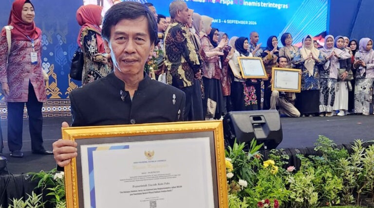 Kadis Perpustakaan dan Kearsipan Kota Palu, Syamsul Saifuddin menunjukkan piagam penghargaan sebagai tiga kota terbaik se-Indonesia dalam inovasi, konsistensi dan implementasi penerapan Aplikasi SRIKANDI oleh LAN RI di Hotel Lombok Raya, Mataram, Selasa (3/9/2024). (Foto: HO-DIskominfosantik Palu)