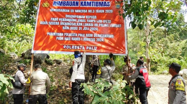 Aparat Polresta Palu memasang baliho imbauan kepada para penambang emas tanpa izin di Kelurahan Poboya beberapa waktu lalu. (Foto: ist)