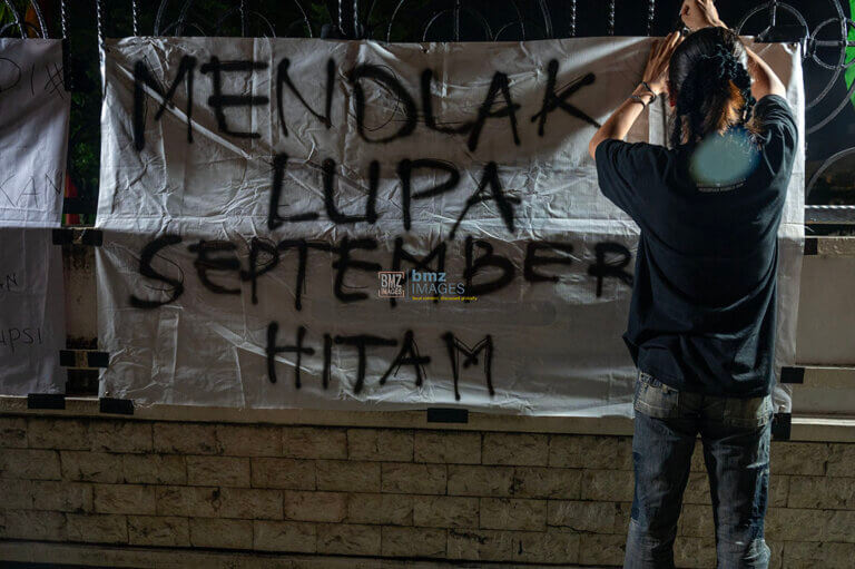 Seorang mahasiswa memasang spanduk pada aksi mimbar bebas Menolak Lupa September Hitam di depan Kantor DPRD Sulawesi Tengah di Palu, Sulawesi Tengah, Jumat (13/9/2024) malam. (bmzIMAGES/Basri Marzuki)