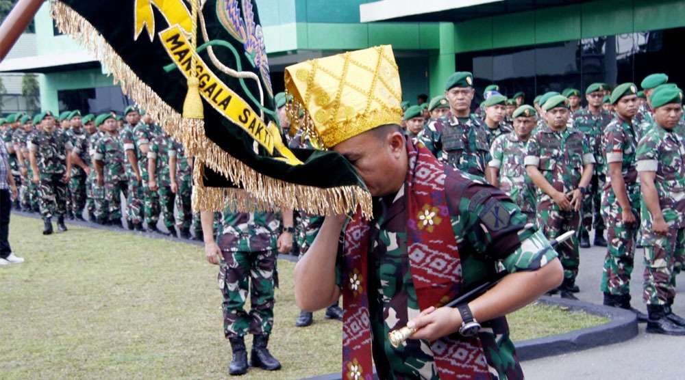 Pejabat baru Danrem 132/Tadulako mencium Dwaja Korem 132/Tdl sebagai simbol kesetiaan terhadap satuan tradisi pada penerimaan di makorem 132/Tdl, Sabtu (7/9/2024). (Foto: Pnerem 132/Tdl)