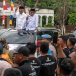 Paslon nomor urut 3 Muhammad J Wartabone (kiri) dan Rizal (kanan) mengangkat tiga jarinya pada konvoi kampanye damai di Palu, Selasa (24/9/2024). (Foto: bmzIMAGES/Basri Marzuki)