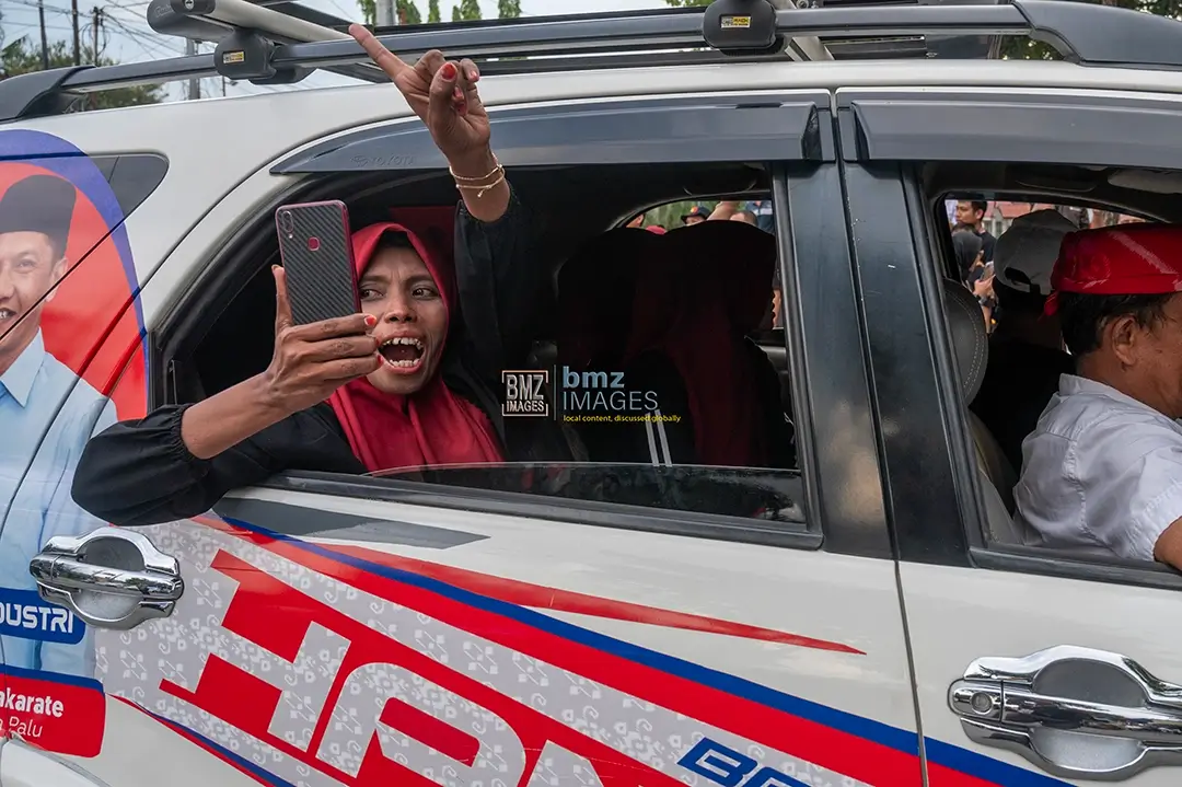 Seorang pendukung salah satu paslon wali kota dan wakil wali kota Palu menunjukkan satu jarinya saat konvoi Kampanye Damai di Palu, Sulawesi Tengah, Selasa (24/9/2024). (bmzIMAGES/Basri Marzuki)