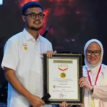 Plh Wali Kota Palu, Irmayanti Pettalolo (kanan) menerima sertifikat rekor MURI atas penyajian ikan mujair kuah asam terbanyak di HUT ke-46 Kota Palu, Lapangan Vatulemo, Sabtu (28/9/2024). (Foto: Prokopim Setda Kota Palu/Jufri)