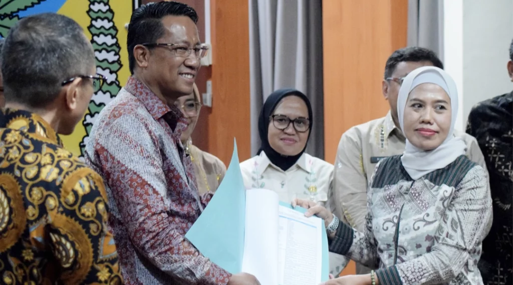 Menkumham, Supratman Andi Agtas (kanan) menyerahkan naskah kepada Direktur SKP-HAM, Nurlaela Lamasitudju (kanan) disaksikan Plh Wali Kota Palu Irmayanti Pettalolo (tengah) di ruang kerja Gubernur Sulteng, kamsi (26/9/2024). (Foto: Prokopim Kota Palu/Imron)