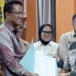 Menkumham, Supratman Andi Agtas (kanan) menyerahkan naskah kepada Direktur SKP-HAM, Nurlaela Lamasitudju (kanan) disaksikan Plh Wali Kota Palu Irmayanti Pettalolo (tengah) di ruang kerja Gubernur Sulteng, kamsi (26/9/2024). (Foto: Prokopim Kota Palu/Imron)