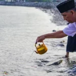 Asisten bidang Administrasi Umum Setda Kota Palu, Imran menuangkan air di Pantai Talise untuk mengenan bencana tsunami di wilayah itu, Sabtu (28/9/2024). (Foto: Prokopim Setda Koat Palu/Iwan)