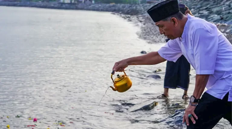 Asisten bidang Administrasi Umum Setda Kota Palu, Imran menuangkan air di Pantai Talise untuk mengenan bencana tsunami di wilayah itu, Sabtu (28/9/2024). (Foto: Prokopim Setda Koat Palu/Iwan)