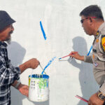 Kasubdit Kamseltibcar lantas Kompol Abu Bakar Djafar menorehkan kuasnya ke dindng menandai pembukaan lomba mural di Layana, Palu, Sabtu (14/9/2024). (Foto: Humas Polda Sulteng)