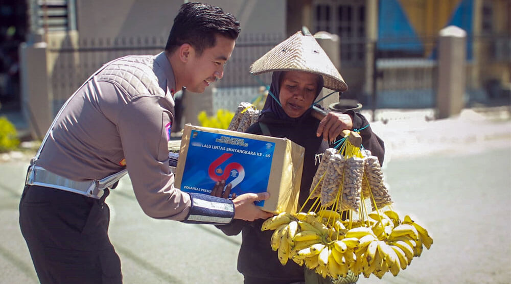 Kasat Lantas Porlesta Palu, AKP Kanisius Franata menyerahka paket sembako kepada seorang penjaja pisang di Palu, Rabu (11/9/2024). (Foto: Humas Polresta Palu)