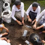 Beberapa pelajar sedang mengisi tanah subur ke dalam polybag untuk media semai salak. (©️FAO/Harriansyah)