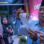 Hidayat menunjukkan nota pembayaran sampah usai debat Pilkada Kota Palu, Senin (21/10/2024). (Foto; bmz)