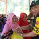 Ketua Tim Wasev, Brigjen TNI Agus Firman Yusmono menyerahkan bantuan ke warga saat meninjau Program TMMD Ke-122 di Desa Bambasiang, Palasa, Parigi Moutong, Rabu ( 23/10/2024). (Foto: Penrem 132/Tdl)