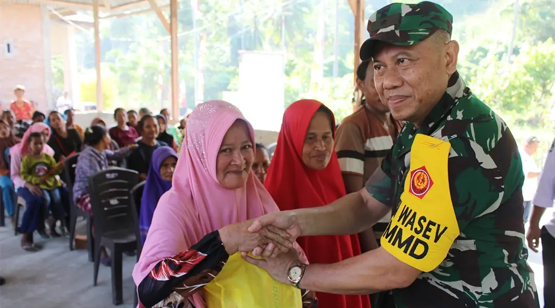Ketua Tim Wasev, Brigjen TNI Agus Firman Yusmono menyerahkan bantuan ke warga saat meninjau Program TMMD Ke-122 di Desa Bambasiang, Palasa, Parigi Moutong, Rabu ( 23/10/2024). (Foto: Penrem 132/Tdl)