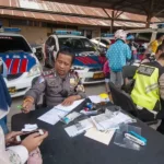 Petugas menilang pengendara sepeda motor pada Operasi Zebra Tinombala 2019 di Palu, Sulawesi Tengah, Sabtu (26/10/2019). (Foto: bmzIMAGES/Basri Marzuki)