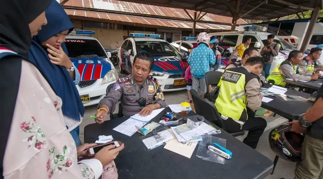Petugas menilang pengendara sepeda motor pada Operasi Zebra Tinombala 2019 di Palu, Sulawesi Tengah, Sabtu (26/10/2019). (Foto: bmzIMAGES/Basri Marzuki)