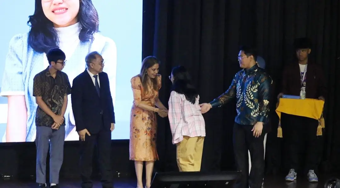Kepala Perwakilan PBB di Indonesia memberikan selamat kepada para pemenang sayembara prangko spesial Hari PBB yang menghadiri penyerahan hadiah; juara 1, Armelsa Ferdinandus dan juara 3, Revant Marloun. (UN Information Centre/Aman Hurd)