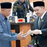 Wakil Ketua DPRD Kota Palu, Moh Anugrah Pratama (kanan) menyerahkan naskah kepada Asisten Bidang Pemerintah dan Kesra Setda Kota Palu pada rapat paripurna DPRD Kota Palu, Rabu (9/10/2024). (Foto: Prokopim Setda Kota Palu/Iwan)