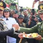 Kapolda Sulteng, Irjen Pol Agus Nugroho (kiri) menyerahkan tumpeng kepada seorang Pamen TNI pada perayaan HUT ke-t9 TNI di Mayonif 711 Raksatama, Palu, Sabtu (5/10/2024). (Foto: Humas Polda Sulteng)