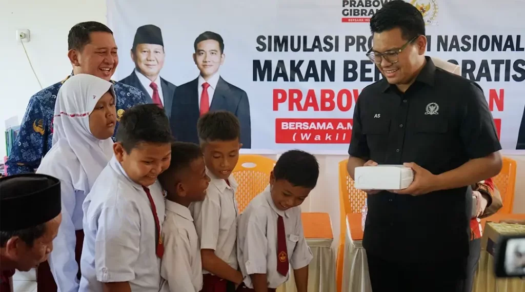 Wakil Ketua MPR RI, Abcandra Muhammad Akbar Supratman (kanan) berasma Pjs Wali Kota Palu, Muchsin Husein Pakaya menyerahkan nasi kotak kepada murid pada simulasi program nasional Makanan Bergizi Gratis di SD Petobo, Palu, Senin (18/11/2024). (Foto: Prokopim Setda Kota Palu/Jufri)