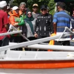 Wali Kota Palu, Hadianto Rasyid (tengah) menyaksikan perahu bantuan di Pantai Tumbelaka, Kamis (28/11/2024). (Foto: Prokopim Setda Kota Palu/Jufri)