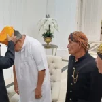Ketua Dewan Adat Pitunggota Sigi, Amin N. Bijasigi menyematkan Siga kepada Ahmad Ali. (Foto:Tim Media Koalisi Beramal)