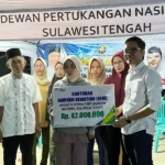 Ketua DPN Sulteng Andri Gultom menyerahkan santunan kematian kepada keluarga dari anggota pekerja bangunan di Kabupaten Sigi sebesar Rp 42 juta (Foto: Koalisi Beramal)