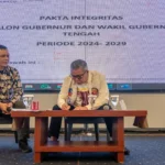 Calon Gubernrur Sulteng nomor urut 1, Ahmad Ali (kanan) meneken pakta integritas berisi komitmen membenahi tata kelola lingkungan, penanganan krisis iklim-energi, serta perlindungan ruang masyarakat adat pada diskusi panel oleh koalisi organisasi jurnalis Sulteng di Palu, Selasa (19/11/2024). (Foto: bmzIMAGES/bmz)