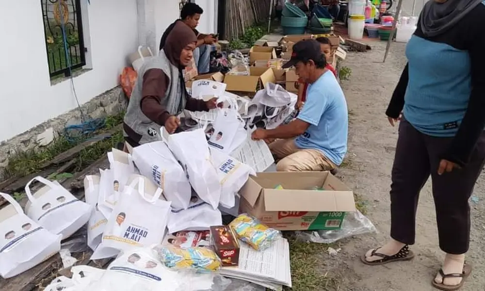 Tim kampanye Beramal sedang memasukkan kertas visi misi, contoh kertas suara dan snack ke dalam goodybag. (Foto: Tim SultengBeramal.com)