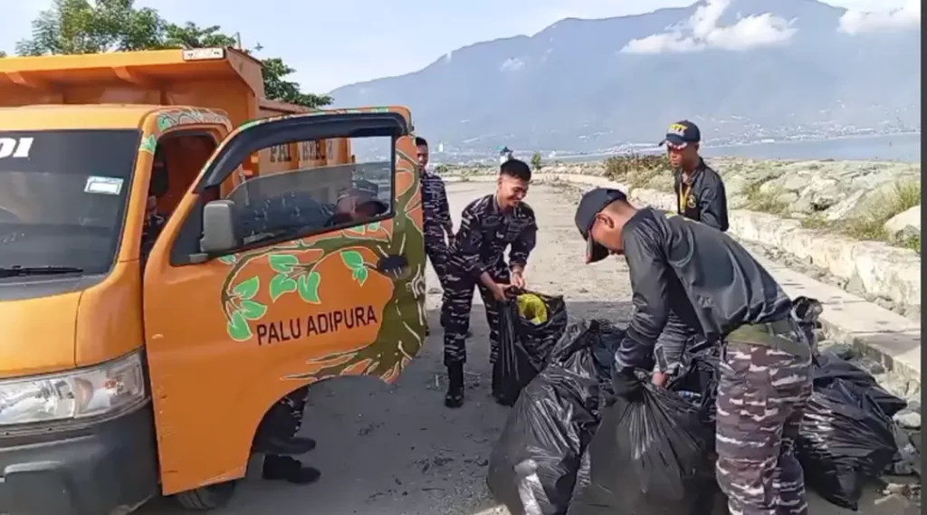 Sejumlah Taruna AAL menaikkan sampah yang dikumpukan ke atas trku pada aksi bersih-bersih pantai dalam rangka Hari Armada ke-79 di pantai kampung Nelayan, Palu, Senin (25/11/2024). (Foto: Lanal Palu)