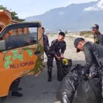 Sejumlah Taruna AAL menaikkan sampah yang dikumpukan ke atas trku pada aksi bersih-bersih pantai dalam rangka Hari Armada ke-79 di pantai kampung Nelayan, Palu, Senin (25/11/2024). (Foto: Lanal Palu)