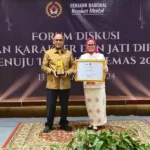 Sekkot Palu, Irmayanti )kanan) bersama Kepala Kesbangpol Kota Palu, Ansyar Sutiadi menunjukkan piagam dan tropi Anugerah Revolusi Mental di Jakarta, Rabu (13/11/2024). (Foto: Prokopim Setda Kota Palu)