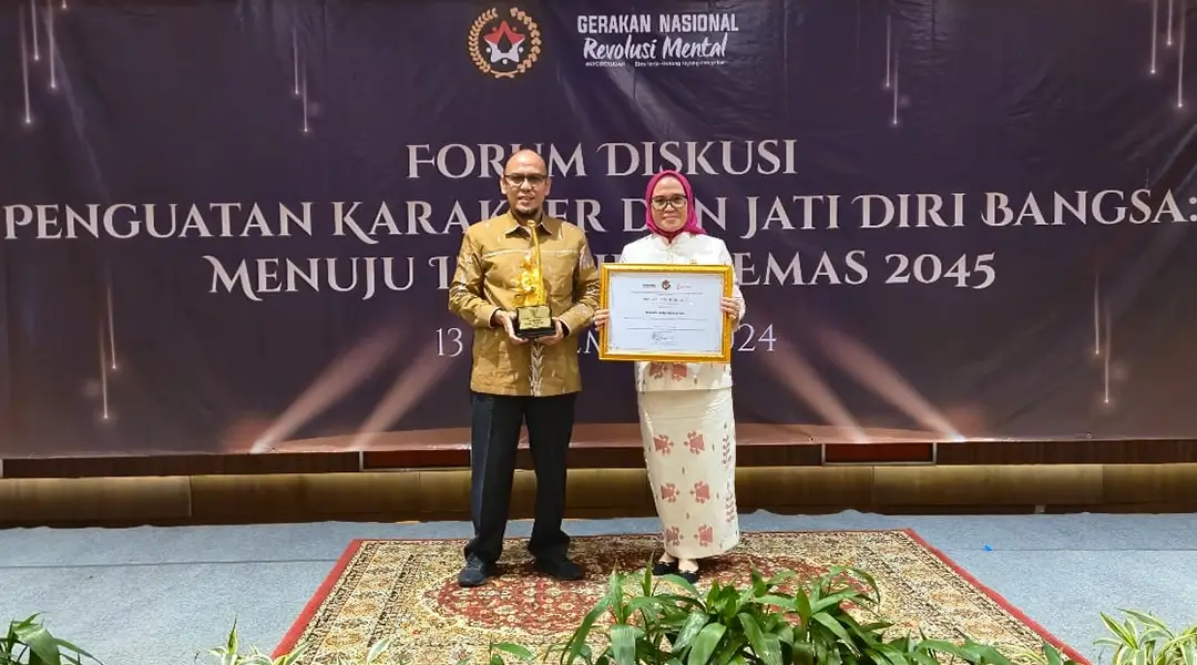 Sekkot Palu, Irmayanti )kanan) bersama Kepala Kesbangpol Kota Palu, Ansyar Sutiadi menunjukkan piagam dan tropi Anugerah Revolusi Mental di Jakarta, Rabu (13/11/2024). (Foto: Prokopim Setda Kota Palu)