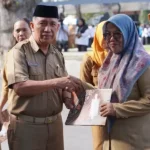 Asisten bidang Administrasi Umum Setda Kota Palu, Imran Lataha (kedua kiri) didampingi Kadis Kesehatan Kota Palu menyerahkan piagam kepada tenaga kesehatan ysaui upacara peringatan Hari Kesehatan Nasonal 2024 di halaman Kantor Wali Kota Palu, Selasa (12/11/2024). (Foto: prokopim Setda Kota Palu/Iwan)