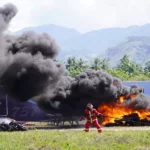 Petugas berusaha memadamkan api yang membakar pesawat pada simulasi keadaan darurat di Bandara Mutiara Sis ALjufri Palu, Kamis (14/11/2024). (Foto: prokopim Setda Kota Palu/Iwan)