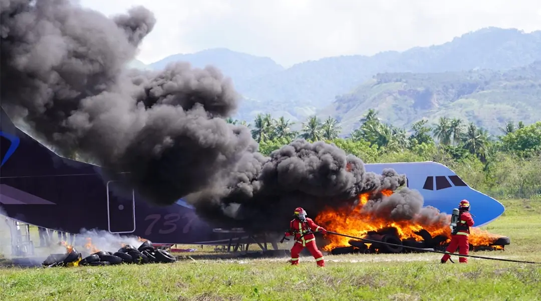 Petugas berusaha memadamkan api yang membakar pesawat pada simulasi keadaan darurat di Bandara Mutiara Sis ALjufri Palu, Kamis (14/11/2024). (Foto: prokopim Setda Kota Palu/Iwan)