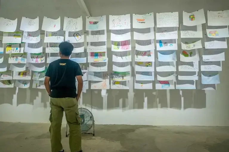 Pengunjung mengamati berbagai tulisan cerita dan gambar dari anak-anak pada pameran bertajuk Yang Kitorang Rasa Waktu Gempa di Palu, Sulawesi Tengah, Senin (4/11/2024). (bmzIMAGES/Basri Marzuki)