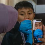 Terapis memeriksa seorang anak sebelum melakukan tindakan terapi wicara di Speech Camp Yayasan Senyum Sulteng di Palu, Sabtu (23/11/2024). (Foto: bmzIMAGES/Basri Marzuki)