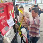 Petugas memasang Police Line saat menyegel dispenser BBM di SPBU di Jalan SIs Lajufri Palu, Selasa (10/12/2024). (Foto: Humas Polresta Palu)