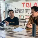 Ketua AJI Palu, Agung Sumandjaya Ikiri) bersama Koordinator Divisi Advokasi, Nurdiansyah (tengah) pada konferensi pers refleksi kasus jurnalis di Sekretariat Bersama Jurnalis di Palu, Selasa (31/1/2/2024). (Foto: Ikram)