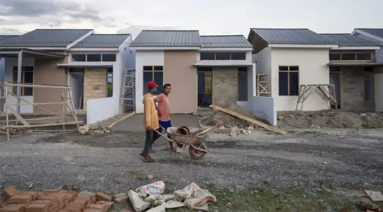 Ilustrasi pekerja melintas di depan sebuah perumahan yang difasilitasi KPR. (Foto: beritapalu.com/basri marzuki)