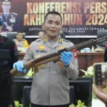Kaops Madago Raya, Kombes POl Boy FS Samola menunjukkan senpi rakita laraas panjang pad akonferensi pers akhir tahun 2024 di Aula RUpatama Polda Sutleng, Selasa (31/12/2024) malam. (Foto: Humas Polda Sulteng)