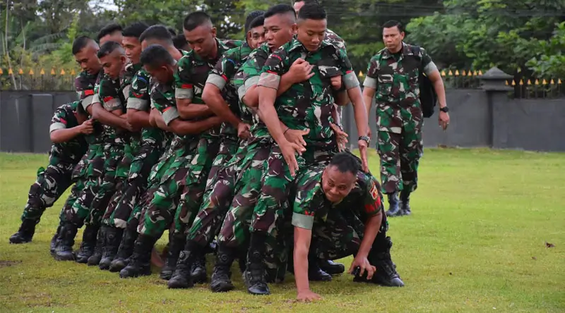 Pangdam XIII Merdeka, Mayjen TNI Suhardi merangkak di bawah prajurit saat mengikuti games di Kompi B Yonif 714/SM, Morowali Utara, Sulawesi Tengah, Kamis (23/1/2025). (Foto: Penrem 132/Tdl)