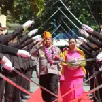 Penjabat baru Kapolresta Palu, Kombes Pol. Deny Abrahams bersana istri berjalan dalam tradisi pedang pora di Mapolresta Palu, Jumat (10/1/2024). (Foto: Humas Polresta Palu)
