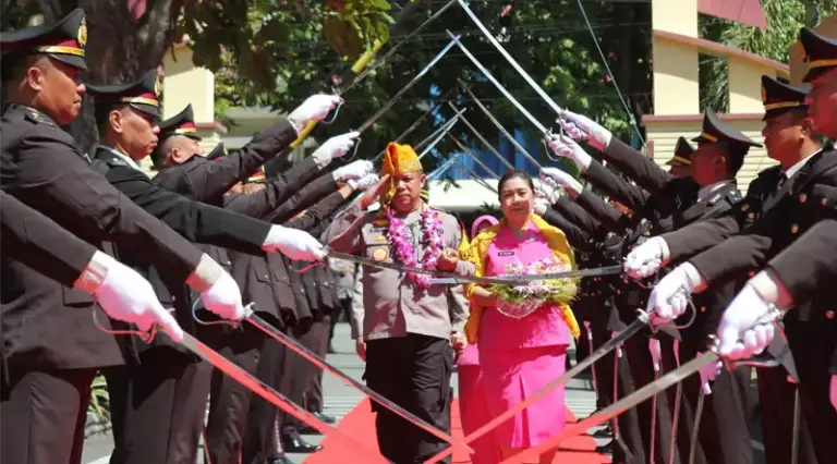 Penjabat baru Kapolresta Palu, Kombes Pol. Deny Abrahams bersana istri berjalan dalam tradisi pedang pora di Mapolresta Palu, Jumat (10/1/2024). (Foto: Humas Polresta Palu)