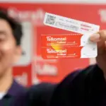 Pelanggan prabayar menunjukkan kartu prabayar Telkomsel dalam program undian berhadiah "Digosok Hepi". (Foto: Telkomsel)